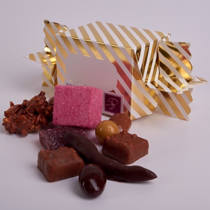 Crackers de Noël de Stéphane Pasco, des Friandises et la traditionnelle devinette, dans une papillote personnalisable.